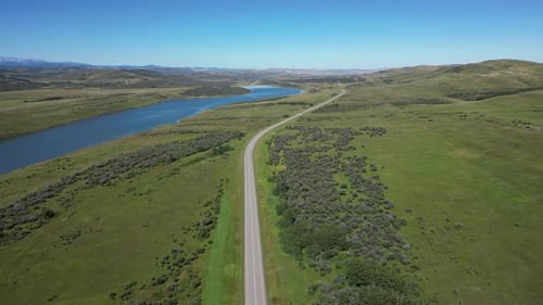 Rodovia da Colúmbia Britânica através de um vale verdejante e lago sereno
