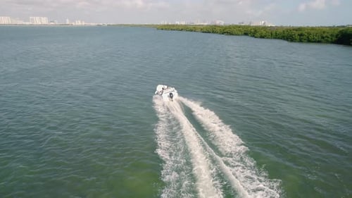 4K footage from drone flying over a boat speeding in the ocean. Speed Boat making waves racing at a