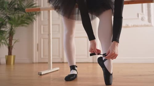 Ballerina Puts on Pointe Shoes on Leg in Dance Class Classical Ballet Dancer Woman in Dance Studio