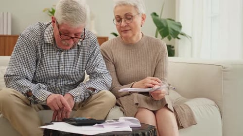 Senior Couple Reviewing Finances at Home on Couch