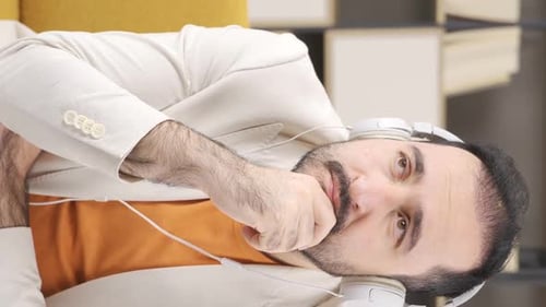 Vertical video of Depressed man listens to slow music.