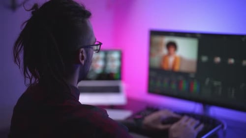 Man Video Editing at Computer Workstation at Night