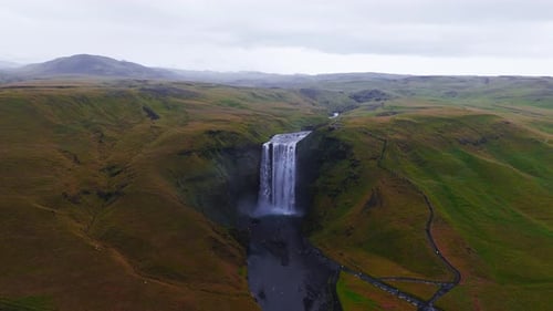 Skogafoss Waterfall Flowing Through Green Cliffs in Iceland