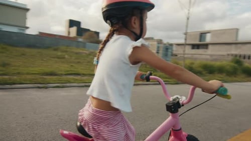 Camera Orbiting Happy Girl with a Pink Bike and Helmet Standing on a Quiet Empty Road