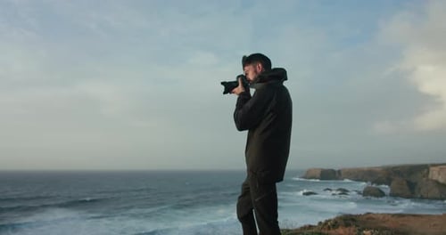 Photographer at Edge of Cliff Over Epic Landscape