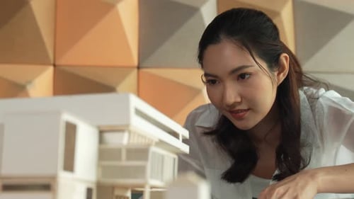 Architecte asiatique professionnel regardant un modèle de maison. Manipulateur.