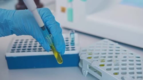 Un chimiste en gros plan a mélangé des produits chimiques à l'aide d'une micropipette pour mettre au point des médicaments et des vaccins potentiels