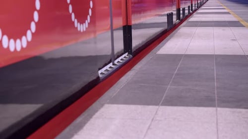 Low angle: Clean red subway train doors close and train leaves station