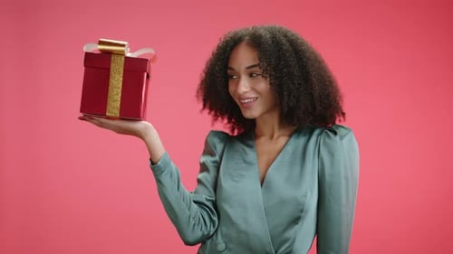 Cheerful Woman Presents a Wrapped Gift