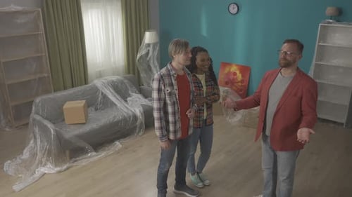 A Real Estate Agent Demonstrates an Apartment to a Couple Talks About Its Advantages Men Shake Hands