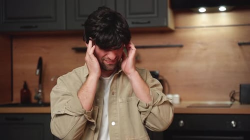 Young Adult Experiencing Headache in Home Kitchen