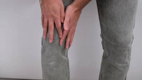 Adult Massaging Knee in Close-Up Shot