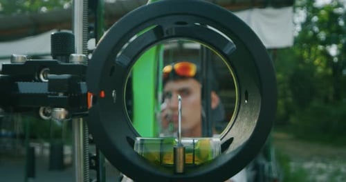 Slow motion viewfinder compound close up of young man with professional equipment is practising ar