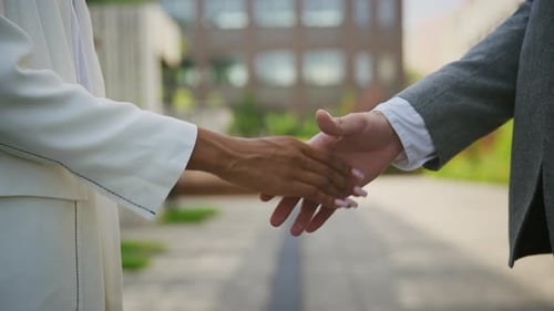 Two Business People Shake Hands on City Street