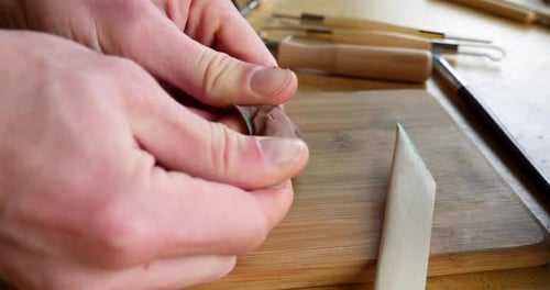 Close up Hands Rolling and Shaping a Small Piece of Polymer Clay