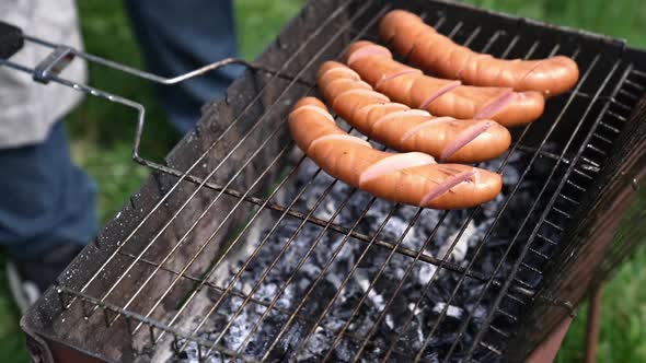 Preparation for grilling sausages. Sausages with incisions on the grill ...