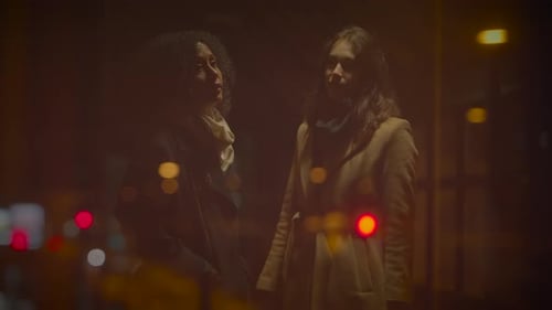 Two Young Adults Talking on Dark City Street