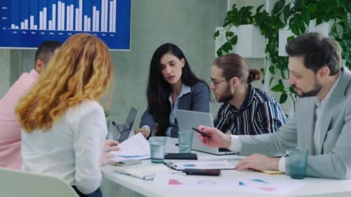 Geschäftsleute am Tisch: Watch berichtet von professioneller Teamarbeit