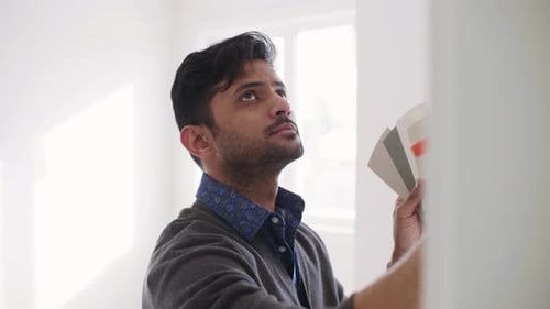 Man choosing wall paint color in new home