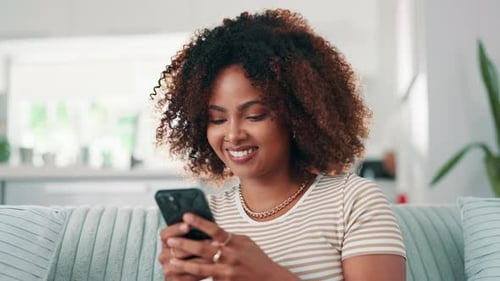 Smiling Woman Using Mobile Phone At Home
