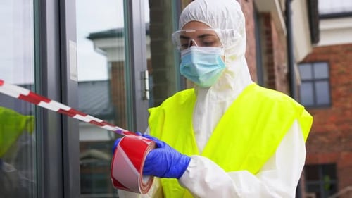 Woman in hazmat suit sealing off building with tape