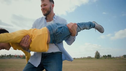 Lächelnder freudiger kaukasischer männlicher Elternteil Mann Vater Vater spielt zusammen, spinnt Sohn wirbelt klein