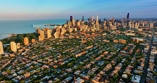 Green uptown and high-rise downtown of Chicago, Illinois in the rays of setting sun.