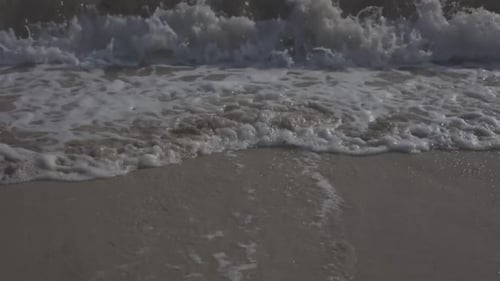 Aufnahme der Küste des schönen Strandes von Juan Dolio bei Sonnenuntergang, Wellen bewegen sich auf dem warmen Sand, wunderschön