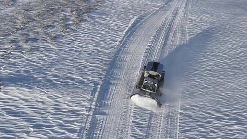 A Snowplow Clears Snow From the Road to Ensure Safe Passage for Vehicles in a Wintry Landscape
