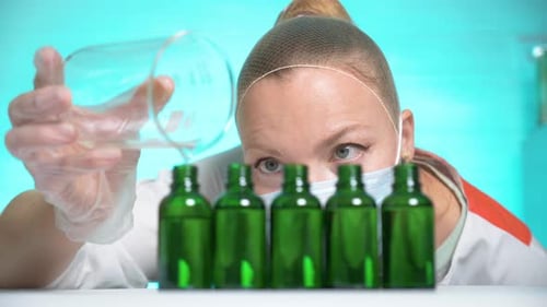 Scientist Pours Liquid into Green Glass Bottles