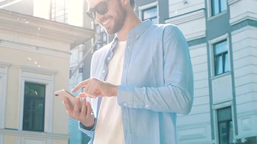 Young Adult Uses Smartphone in City Street