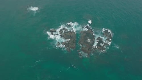 Waves Crash Against Rocks in the Ocean