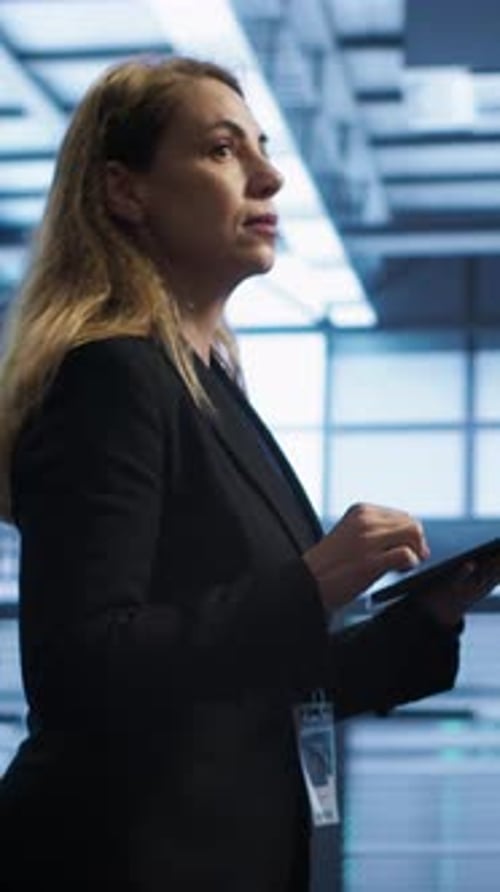 Vertical Video Woman in Data Center Making Sure Rigs are Functioning Optimally