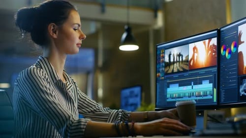 Female Video Editor Works with Footage and Sound on Her Personal Computer. She Works Late and Drink