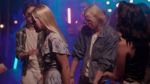 Mädchen und Männer tanzen zusammen und genießen nachts Partymusik und haben Spaß beim Feiern am Wochenende