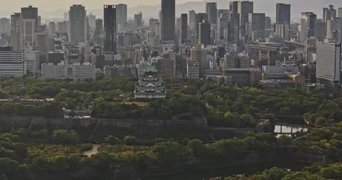 Osaka Japan Aerial v66 flyover Osakajo park capturing Castle against downtown cityscape, showcasing
