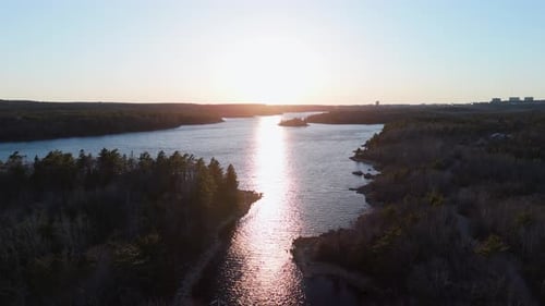 Cinematic Drone View of a Wild Forest and Lake Long Lake with a Beautiful Sunset