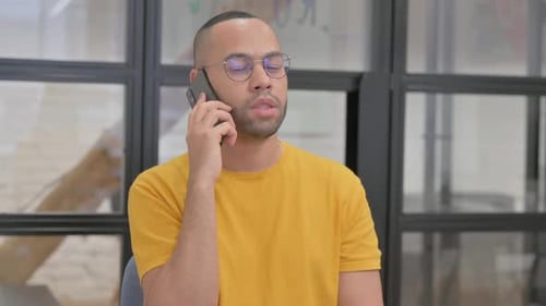 Young Adult Talking on Smartphone Indoors