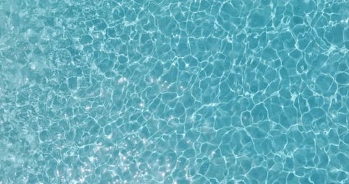 Blue Water in the Swimming Pool with Light Reflections