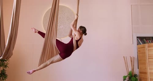 Woman in Aerial Yoga Pose in Bright Studio