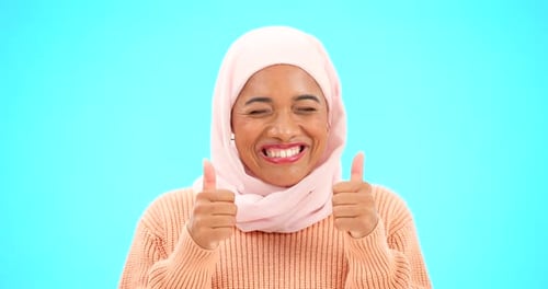 Muslimische Frau, glücklich und mit dem Daumen hoch im Porträt im Studio für Modell, Werbung oder Verkaufsförderung