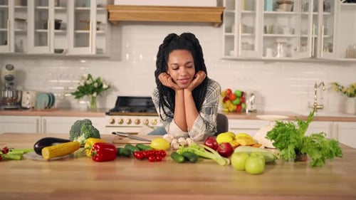 Woman in Kitchen with Fresh Vegetables Displayed