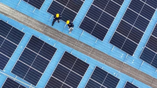 Aerial view of solar photo voltaic panels system on building roof. Renewable ecological green energy