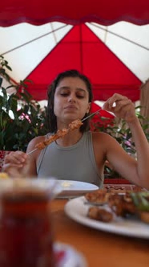 Young Woman Enjoys Delicious Kebab at Restaurant