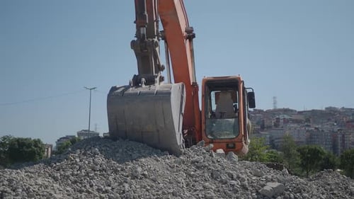 A Machine Excavates Rocks with a Bulldozer on the Hill Slope