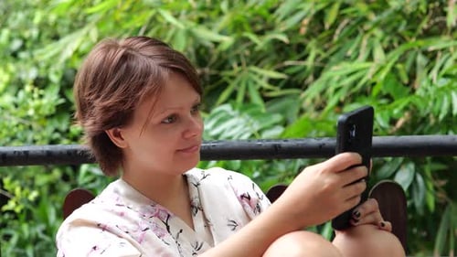 Young Woman Using Smartphone While Sitting on Terrace
