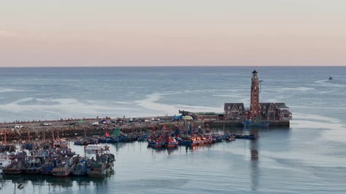 Picturesque Harbor With Boats and Lighthouse at Sunrise