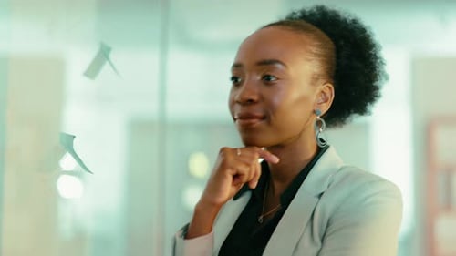 Woman Writing on Glass Wall in Office