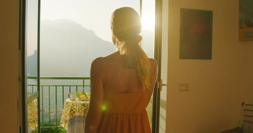Woman Enjoys Picturesque Mountain View from Apartment Balcony