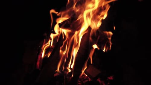 A burning log fire in the night, slow motion capture.
